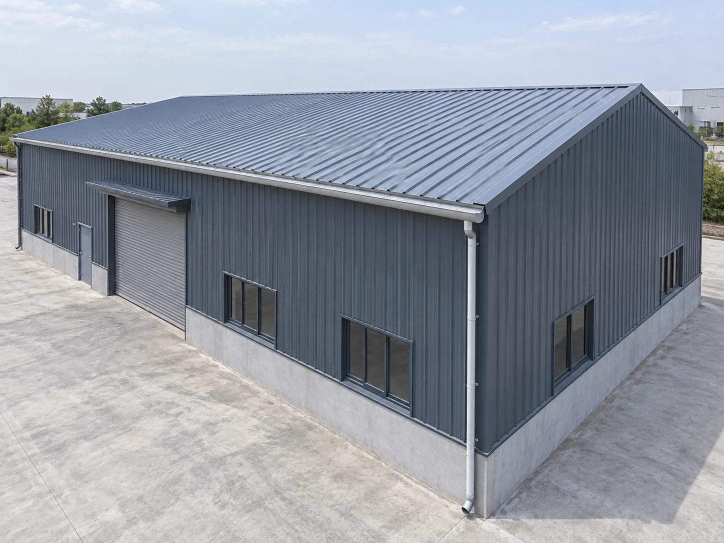 Exterior of an industrial steel building with a profiled steel roof, eave gutter and downspout